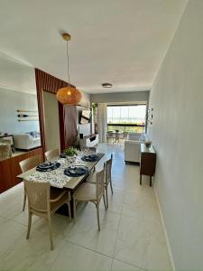 comedor y sala de estar con mesa y sillas en Apartamento vista mar Atalaia todos quartos climatizados, en Aracaju