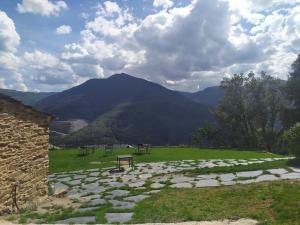 a stone path in a field with mountains in the background at Eco dos Teixos in Casayo