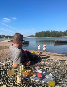 un uomo seduto a un tavolo da picnic con cibo di Aurora Igloo Porvoo a Porvoo