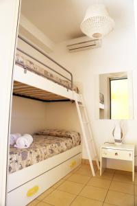 ein Schlafzimmer mit Etagenbetten und einem Spiegel in der Unterkunft La stella di Montalbano con parcheggio privato in Punta Secca