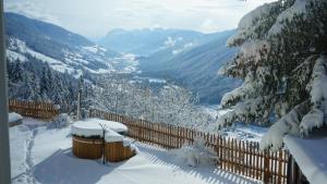 a snow covered fence with a view of a valley at Hotel Almhof in San Candido