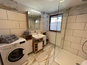 ein Badezimmer mit einer Waschmaschine und einem Waschbecken in der Unterkunft Haus-Ennstal in Öblarn