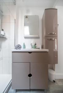 a bathroom with a sink and a mirror at Le Louis B - Appartement calme et lumineux proche Thermes in Vichy