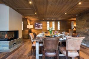 een eetkamer met een tafel en een open haard bij Chalet Ambre in Tignes +9 foto's