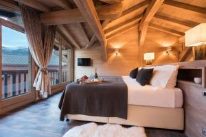 een slaapkamer met een bed en een groot raam bij Chalet Ambre in Tignes