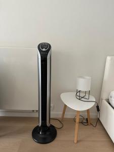 a black floor lamp next to a table and a bed at Beach-la-Mar in Knokke-Heist