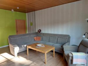 ein Wohnzimmer mit einem Sofa und einem Couchtisch in der Unterkunft Ferienwohnung am Drömling Südheide - Gerda in Bergfeld