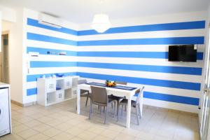 a dining room with a blue and white striped wall at La stella di Montalbano con parcheggio privato in Punta Secca