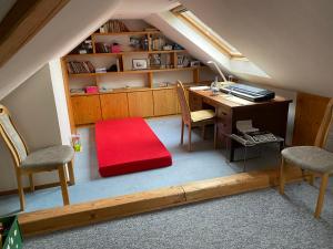 Oberfell的住宿－Ferienwohnung Unter dem Schild，阁楼间配有桌椅和红色地毯。