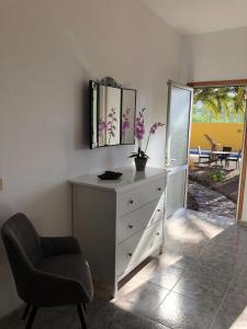 ein Schlafzimmer mit einer Kommode, einem Stuhl und einem Spiegel in der Unterkunft Apartamentos Casa Rosán, junto a la Caldera de Taburiente in El Paso