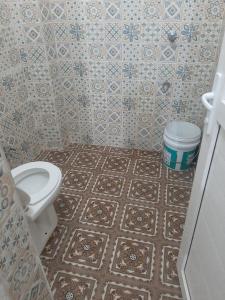 a bathroom with a toilet and a tiled floor at Hotel Vaidehi in Varanasi