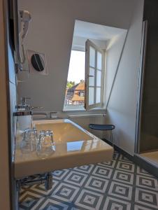 a bathroom with a tub and a sink and a window at Hotel Fürstenhof in Büdingen