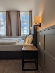 1 dormitorio con cama, lámpara y mesa en Hotel Fürstenhof en Büdingen