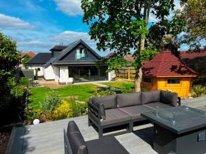 a patio with a couch and a table and a house at BOURNECOAST - Bungalow-Garden-BBQ hut-WIFI- HB6339 in Bournemouth