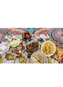 einen Tisch mit Teller mit Lebensmitteln auf einem Tisch in der Unterkunft Nile Felucca Adventure in Assuan