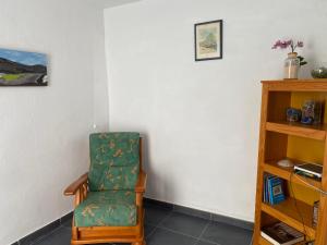 a chair sitting in a corner of a room at Mirador del muelle house in Órzola