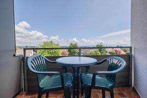 a table and two chairs on a balcony with a view at Ferienwohnpark Immenstaad am Bodensee Ein-Zimmer-Apartment 49 41 in Immenstaad am Bodensee +1 photo
