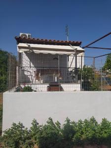 Budowa budynku za białą ścianą w obiekcie Melina's comfort rustic home w mieście Artemida