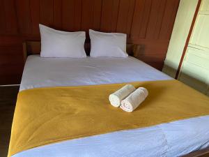 two rolls of toilet paper sitting on top of a bed at Souksanh Guesthouse in Ban Donsôm