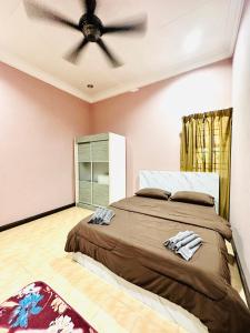 una camera con letto e ventilatore a soffitto di RP Guest House a Kota Bharu