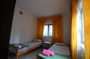 Habitación pequeña con 2 camas y ventana en Hostel Aeropuerto Ezeiza en Monte Grande