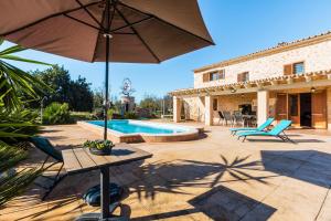 un patio con sombrilla y piscina en Buger - 3721 Mallorca, en Búger