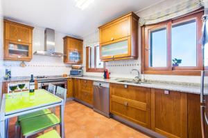 una cocina con armarios de madera y electrodomésticos de acero inoxidable en Buger - 3721 Mallorca, en Búger