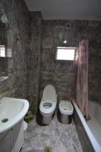 a bathroom with a sink and a toilet and a tub at Hostel Aeropuerto Ezeiza in Monte Grande