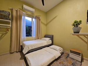 - 2 lits dans une chambre avec fenêtre dans l'établissement Homestay Rumah Tengok Jelawat Bachok, à Bachok