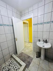 a bathroom with a white sink and a door at Résidence Lacolombe in Petit-Canal