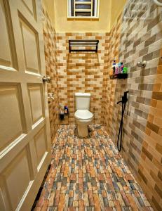 a bathroom with a toilet and a tiled floor at Homestay Rumah Tengok Jelawat Bachok in Bachok