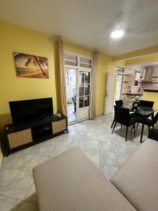 a living room with a couch and a tv and a table at Résidence Lacolombe in Petit-Canal +13 photos