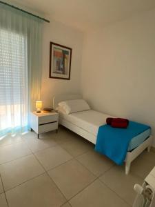 Schlafzimmer mit einem Bett, einem Tisch und einem Fenster in der Unterkunft Sunny House Fourteen in Assemini