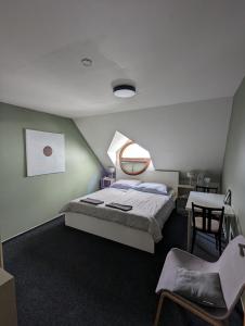 a bedroom with a bed and a table and a chair at Hostel John Galt in Brno