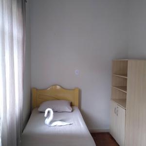 a bedroom with a swan statue on a bed at POUSADA DO JOAO in Juiz de Fora