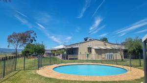a pool in front of a house with a fence at 505 CONROD STRAIGHT MOUNT PANORAMA in Bathurst