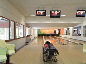 a bowling alley with two lanes and two televisions at Holiday Home Rosapineta Camping Village-3 by Interhome in Rosapineta