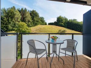 a patio with two chairs and a table on a deck at Apartment Elisabeth by Interhome in Egg am Faaker See
