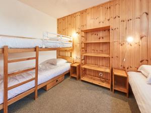 2 stapelbedden in een kamer met houten wanden bij Apartment Greppon 306 by Interhome in Les Collons