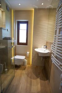La salle de bains est pourvue d'un lavabo et de toilettes. dans l'établissement Beskid Rose & SPA, à Słopnice
