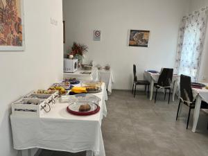 una cucina con tavoli bianchi con sopra del cibo di ANGI B&B a Budrio