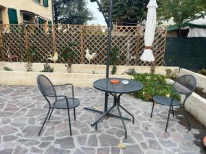a patio with a table and two chairs and an umbrella at ANGI B&B in Budrio +6 photos