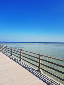 a wooden pier with the ocean in the background at Apartment inside 5* star hotel private beach with reef (FOREIGNERS ONLY) in Hurghada