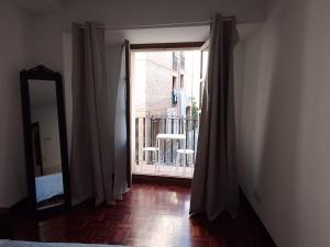 um quarto com uma porta para uma varanda com um espelho em CASA DORMILATERIA - Habitación em Pamplona