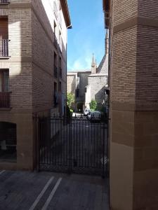 um beco com um portão preto e uma igreja em CASA DORMILATERIA - Habitación em Pamplona