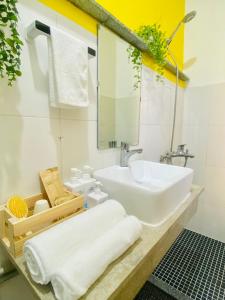 La salle de bains est pourvue d'un lavabo blanc et d'un miroir. dans l'établissement Tiny Homes- Vintage Apartments, à Hanoï