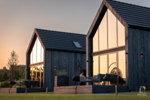 a house with a black roof and windows at Sunset House & Spa in Ustrzyki Dolne