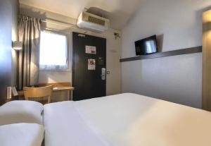 a hotel room with a bed and a table and a window at B&B HOTEL La Rochelle Angoulins in Angoulins-sur-Mer