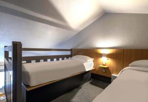 a bedroom with two beds and two lamps in it at B&B HOTEL La Rochelle Angoulins in Angoulins-sur-Mer