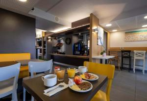 - une salle à manger avec une table et des aliments pour le petit-déjeuner dans l'établissement B&B HOTEL La Rochelle Angoulins, à Angoulins-sur-Mer